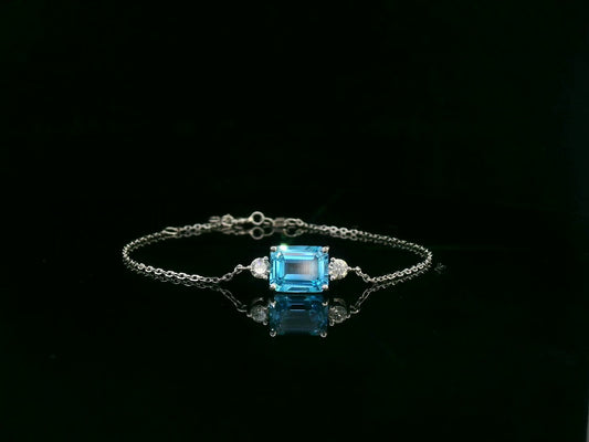 18K white gold Swiss blue topaz bracelet with emerald-cut center stone and diamond accents – Emirates Diamonds