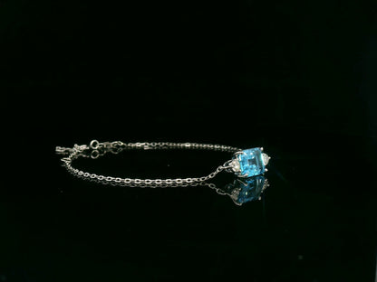 18K white gold Swiss blue topaz bracelet with emerald-cut center stone and diamond accents – Emirates Diamonds