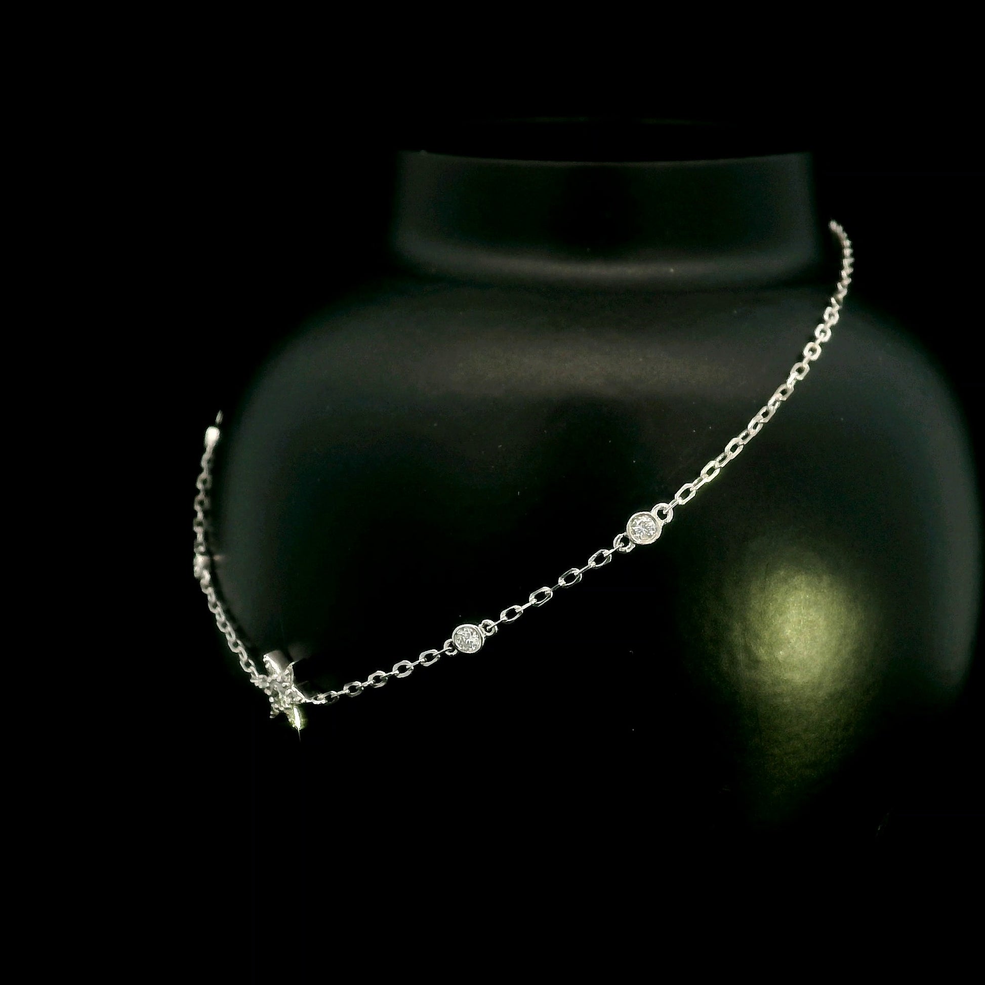 Diamond chain bracelet in 18K white gold featuring a pavé diamond star motif with bezel-set station diamonds totalling 0.16 carat.