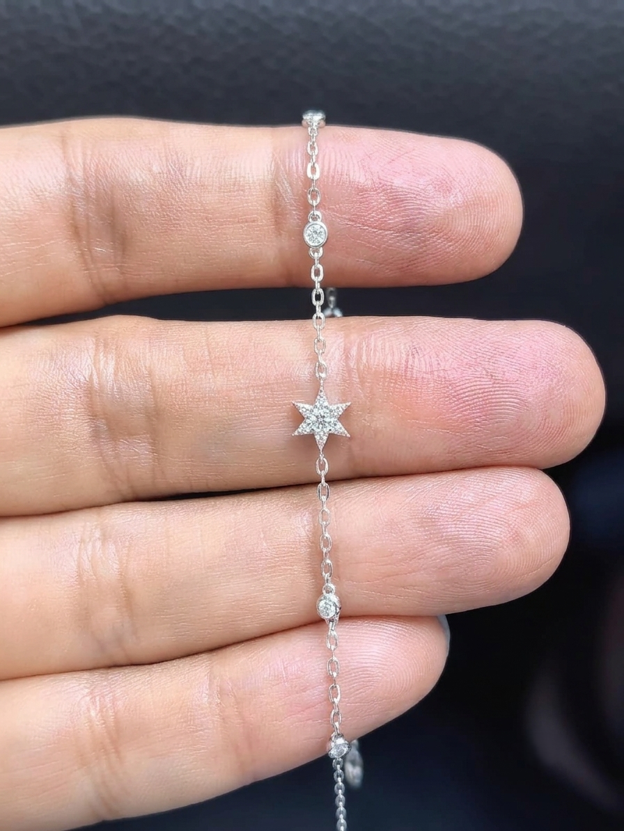 Diamond chain bracelet in 18K white gold featuring a pavé diamond star motif with bezel-set station diamonds totalling 0.16 carat.