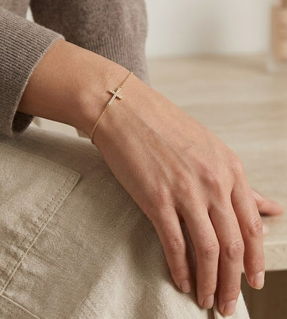 18K yellow gold sideways diamond cross bracelet with round natural diamonds and adjustable fine gold chain