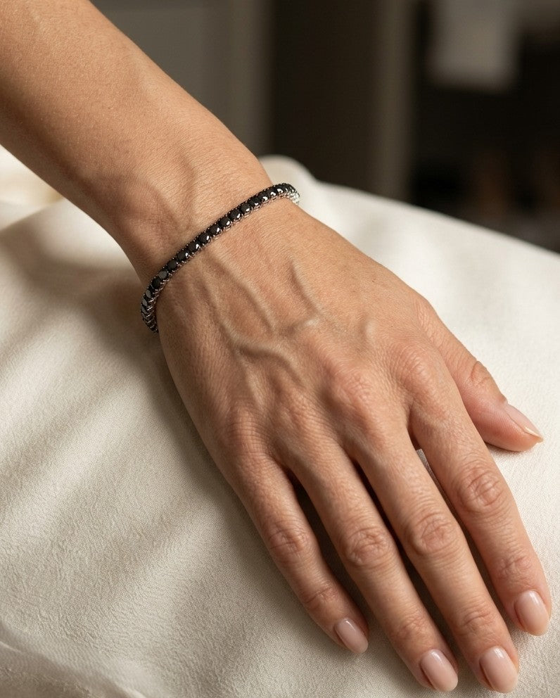 18K white gold black diamond tennis bracelet featuring a continuous row of round natural black diamonds totaling 8.38 carats