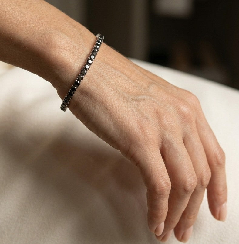 18K white gold black diamond tennis bracelet featuring a continuous row of round natural black diamonds totaling 8.38 carats