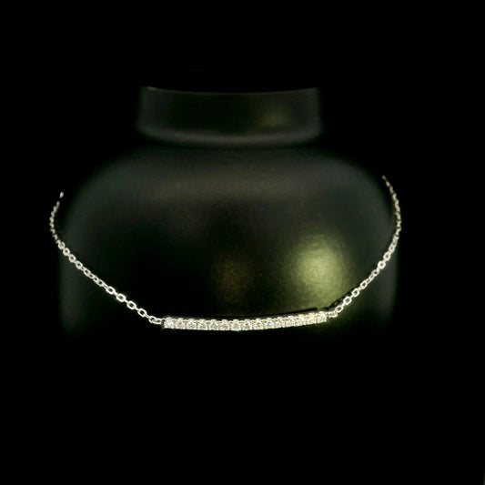 Diamond bar bracelet in 18K white gold featuring a curved row of round brilliant diamonds on a fine chain.