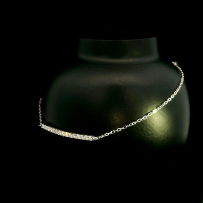 Diamond bar bracelet in 18K white gold featuring a curved row of round brilliant diamonds on a fine chain.