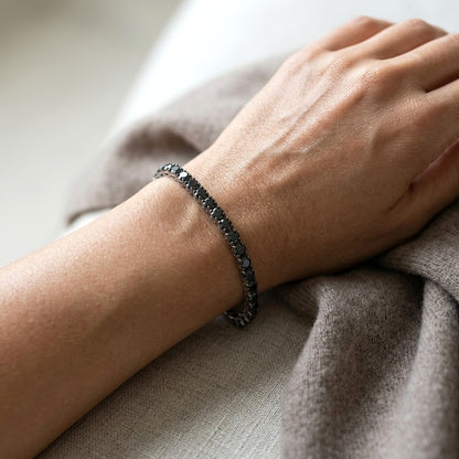 Black diamond tennis bracelet in 18K white gold with a continuous single row of round black diamonds