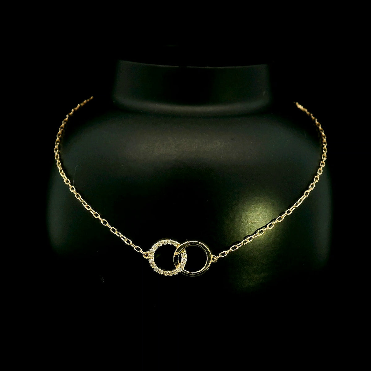 18K yellow gold diamond circle bracelet with two interlocking rings, featuring one polished gold circle and one round diamond-set circle