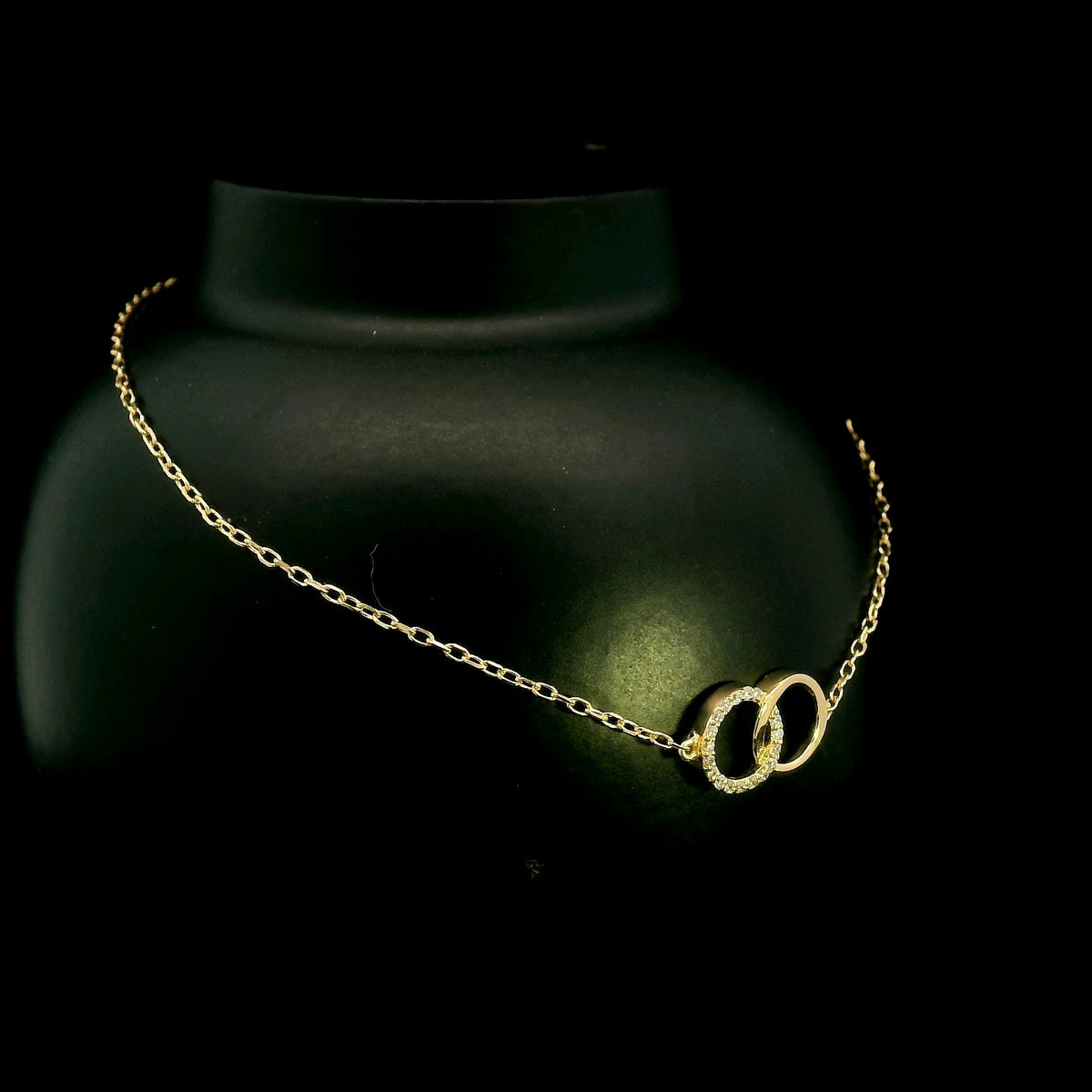18K yellow gold diamond circle bracelet with two interlocking rings, featuring one polished gold circle and one round diamond-set circle