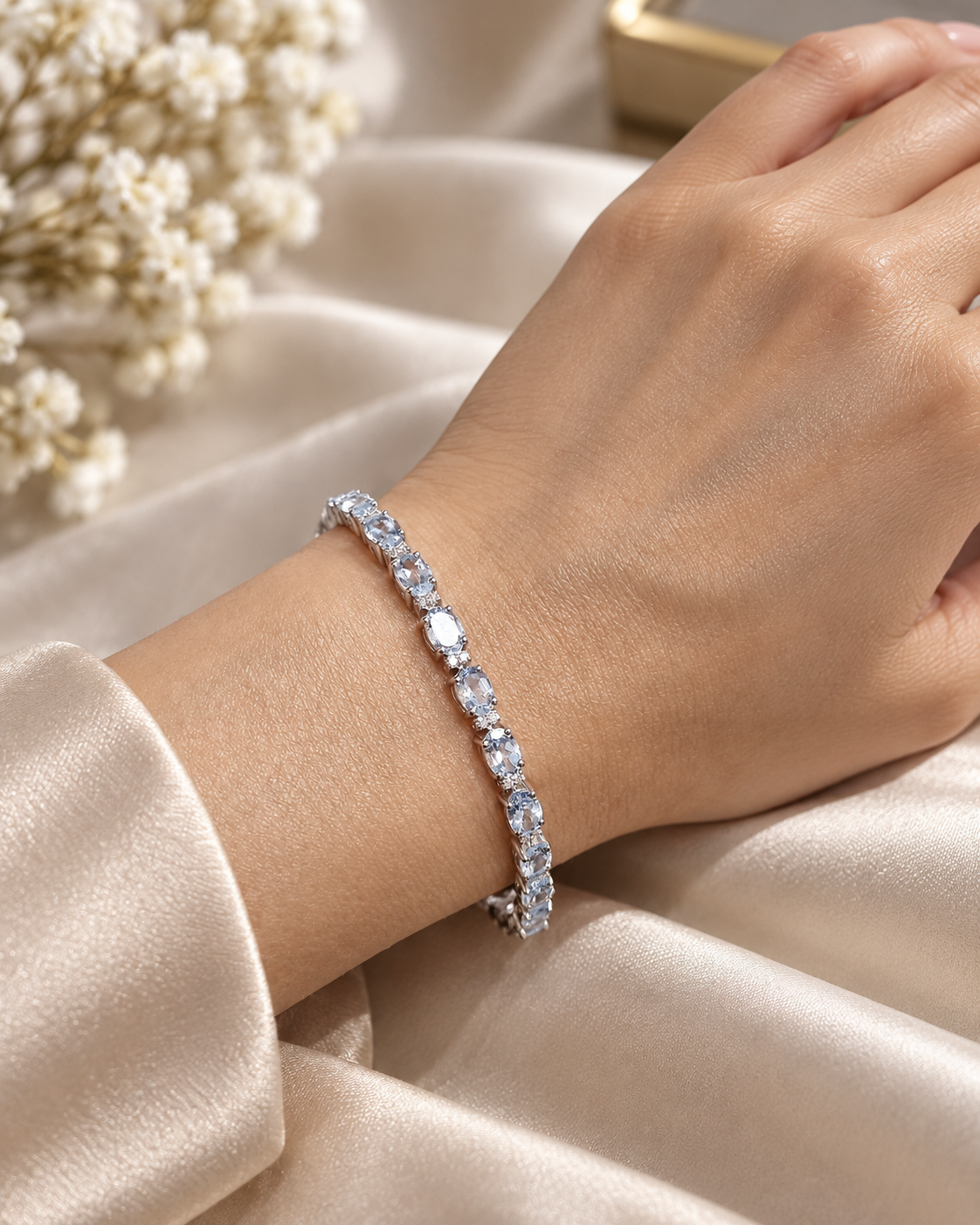 Aquamarine tennis bracelet in 18K white gold featuring oval blue aquamarine gemstones and sparkling diamond accents.