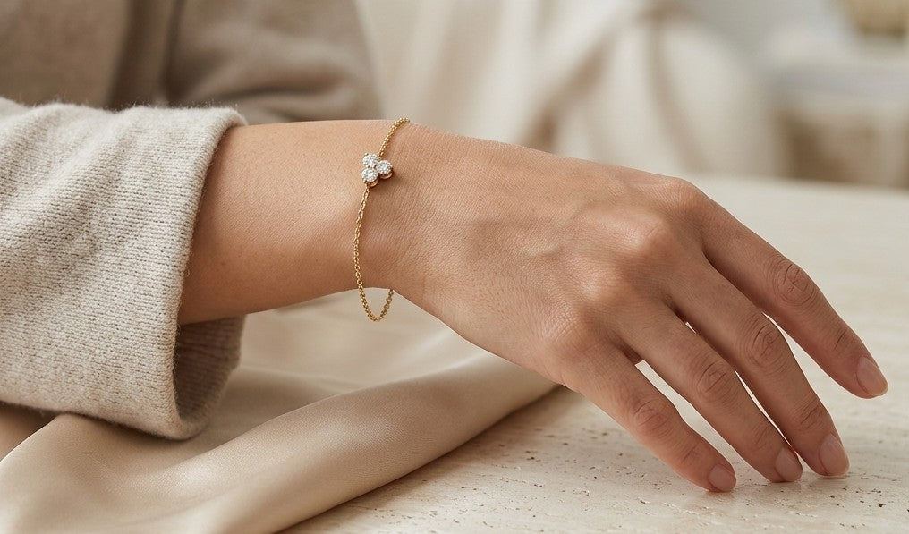18K yellow gold diamond cluster bracelet featuring three round diamonds in a central prong setting on a delicate gold chain.
