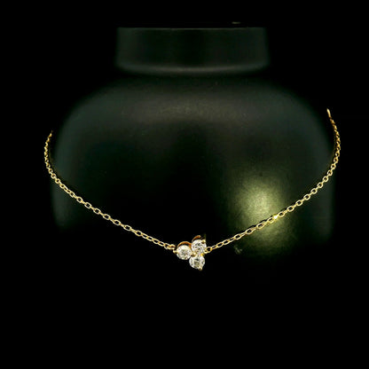 18K yellow gold diamond cluster bracelet featuring three round diamonds in a central prong setting on a delicate gold chain.