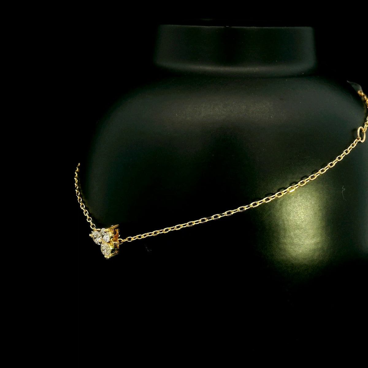 18K yellow gold diamond cluster bracelet featuring three round diamonds in a central prong setting on a delicate gold chain.