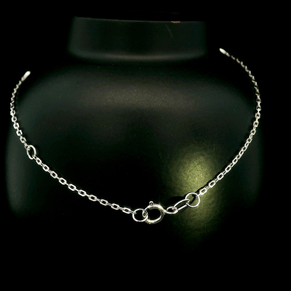 18K white gold diamond station bracelet featuring a central three-diamond cluster and four bezel-set round diamond stations along a delicate chain.