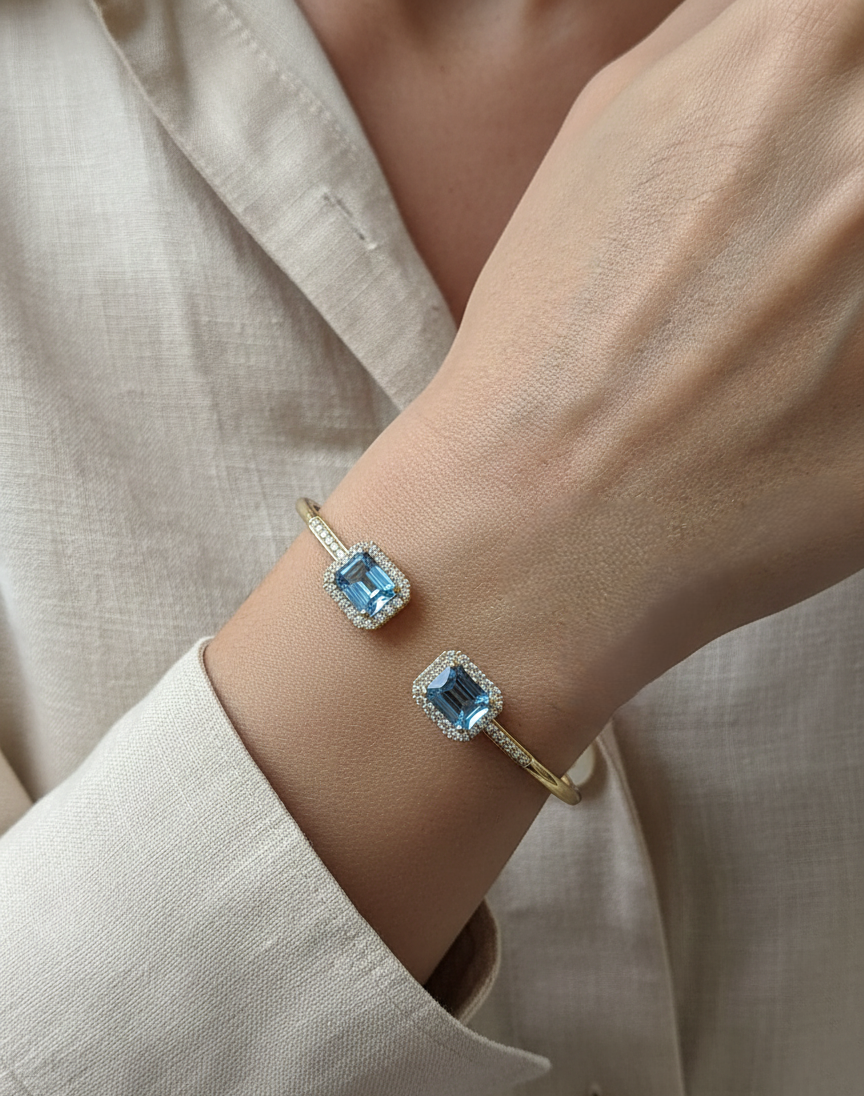 Blue topaz and diamond open cuff bangle bracelet in 18K yellow gold by Emirates Diamonds