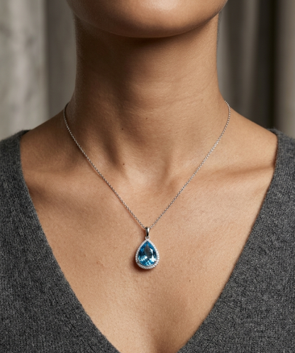 18K white gold pear shape London Blue Topaz pendant with diamond halo featuring a 9.10 carat natural London Blue Topaz and 0.39 carat natural diamonds.