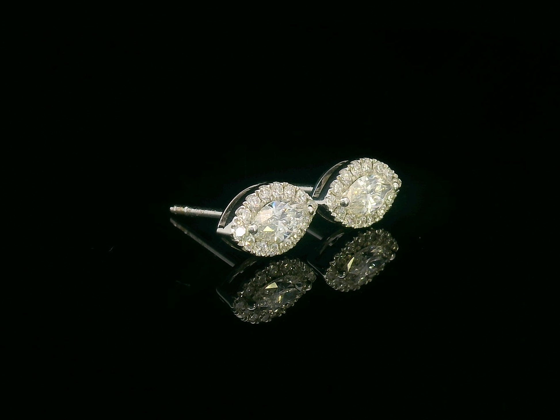 18K gold marquise diamond halo stud earrings with round-cut diamond accents – 0.69 carat total weight

