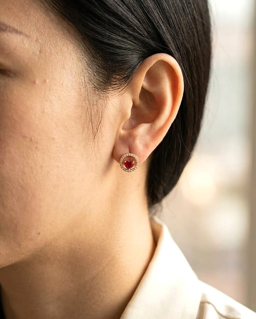 Heart shaped ruby and diamond halo stud earrings in 18K yellow gold by Emirates Diamonds