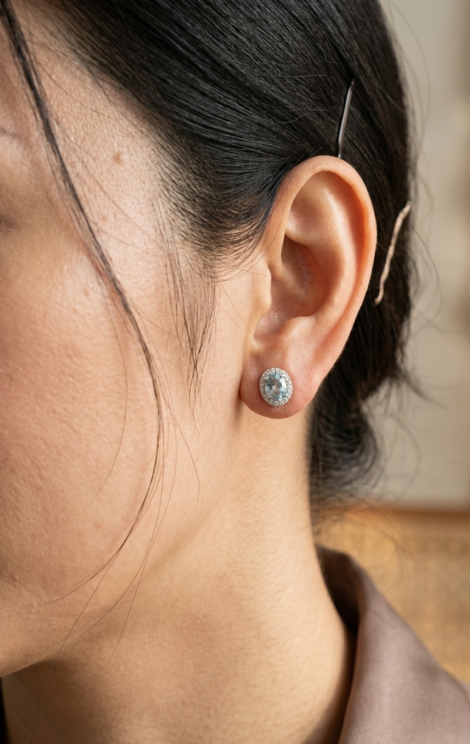 18K white gold aquamarine and diamond halo stud earrings with oval aquamarines.