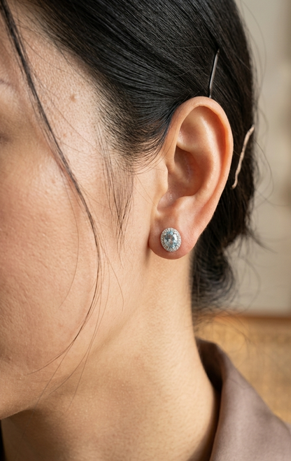 18K white gold aquamarine and diamond halo stud earrings with oval aquamarines.