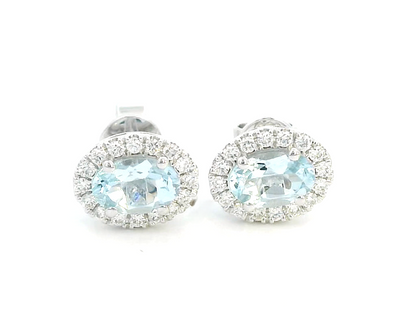 18K white gold aquamarine and diamond halo stud earrings with oval aquamarines.