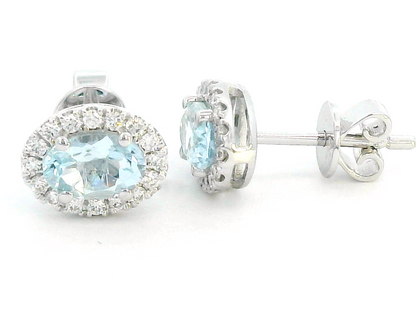 18K white gold aquamarine and diamond halo stud earrings with oval aquamarines.