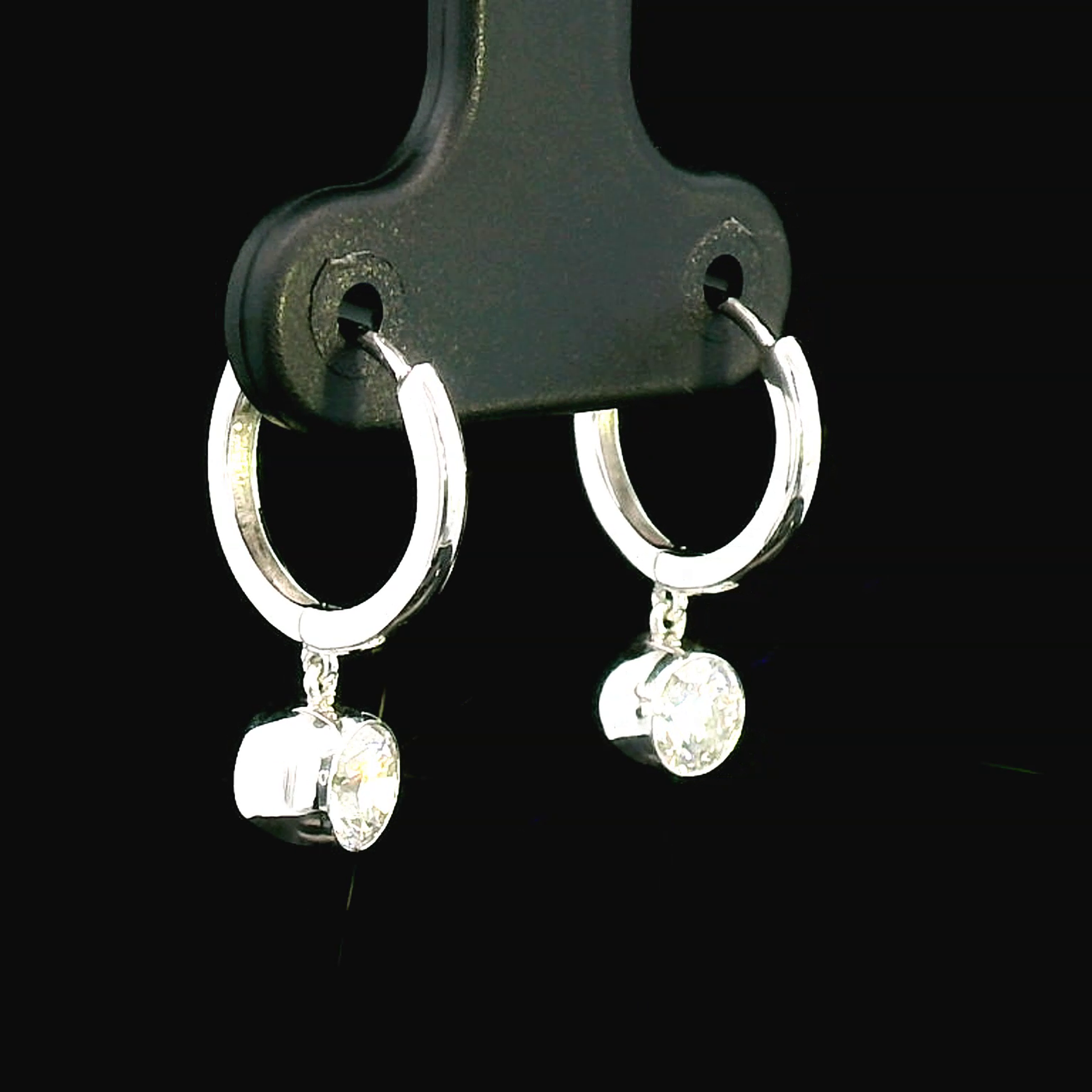 18K gold dangle hoop earrings with 0.57 carats bezel-set diamonds.