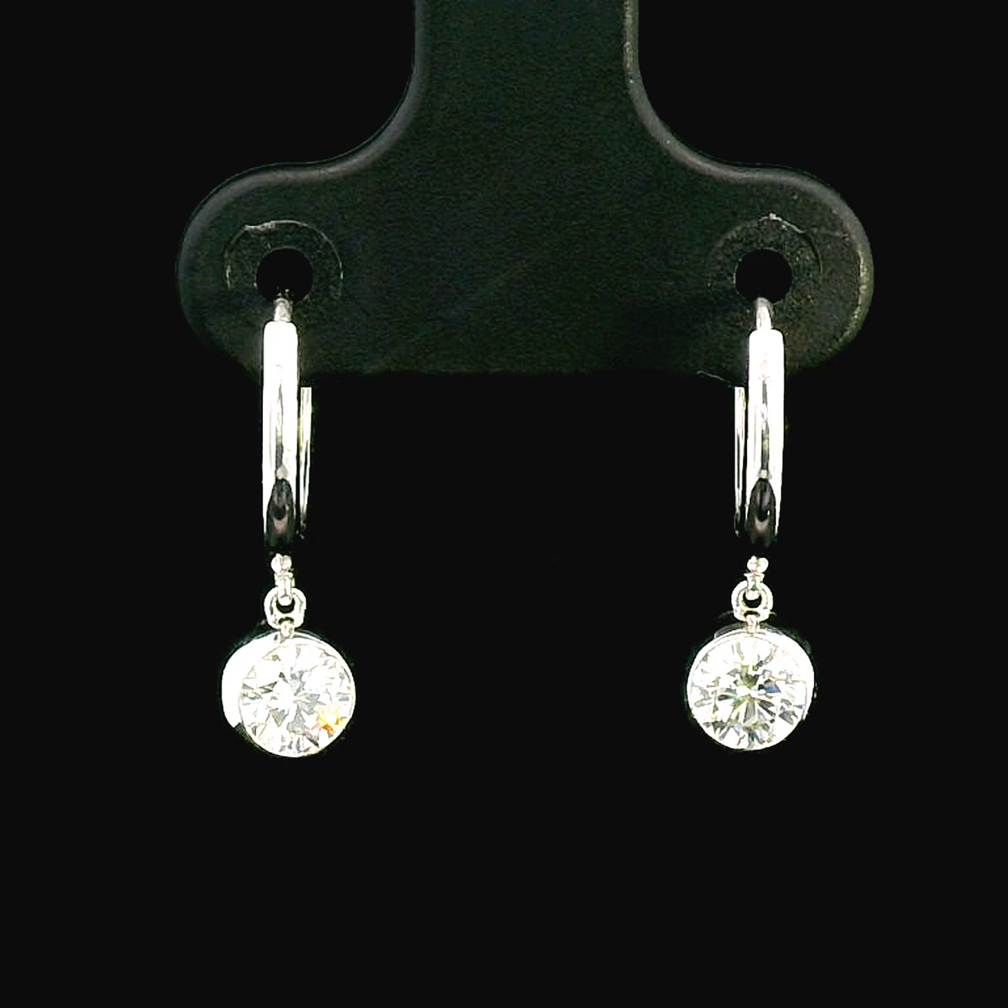 18K gold dangle hoop earrings with 0.57 carats bezel-set diamonds.