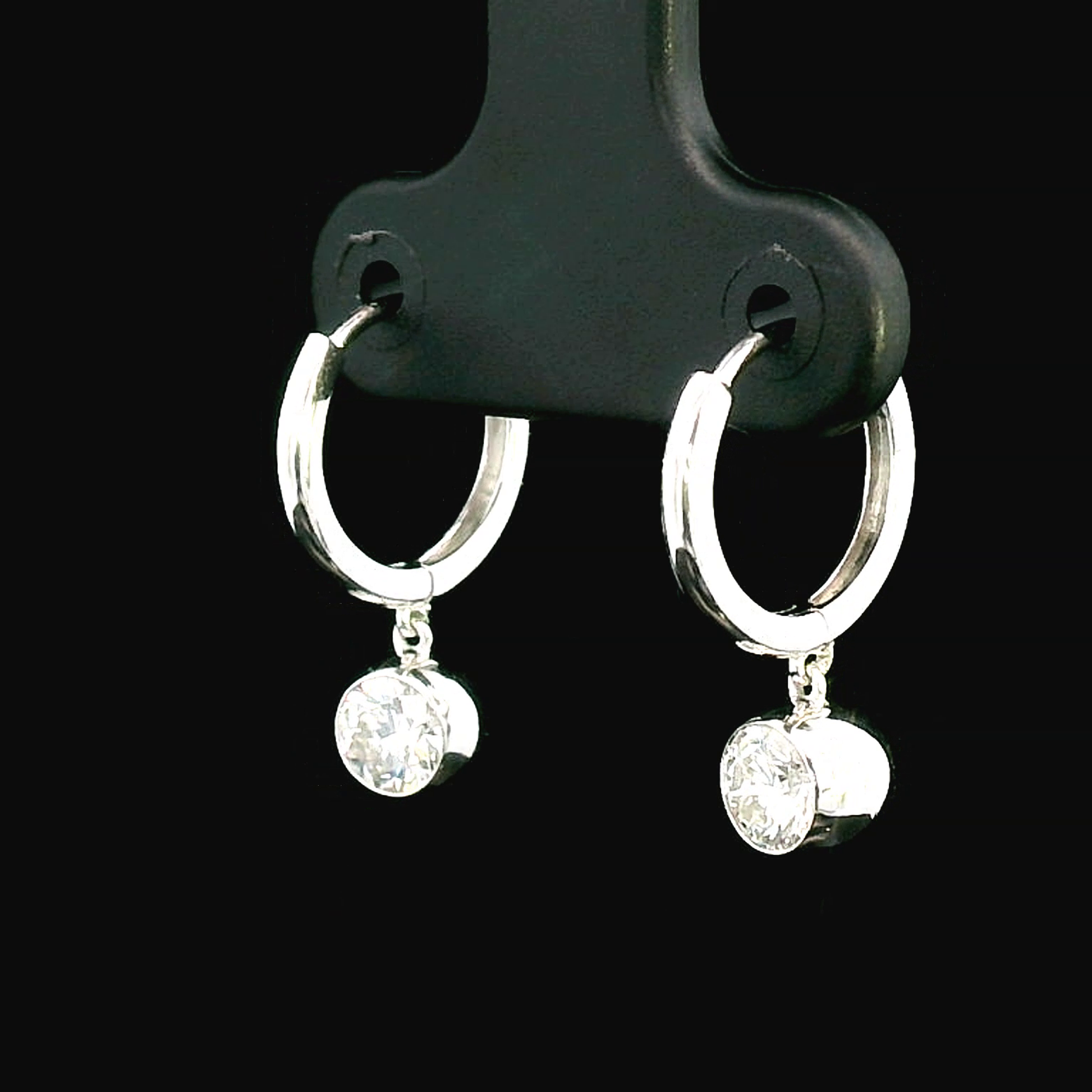 18K gold dangle hoop earrings with 0.57 carats bezel-set diamonds.