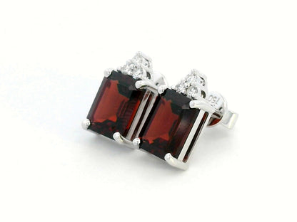 18K white gold garnet and diamond stud earrings featuring emerald-cut garnets (4.11 CT total) with a delicate diamond cluster (0.09 CT total), set in a classic and elegant stud design.