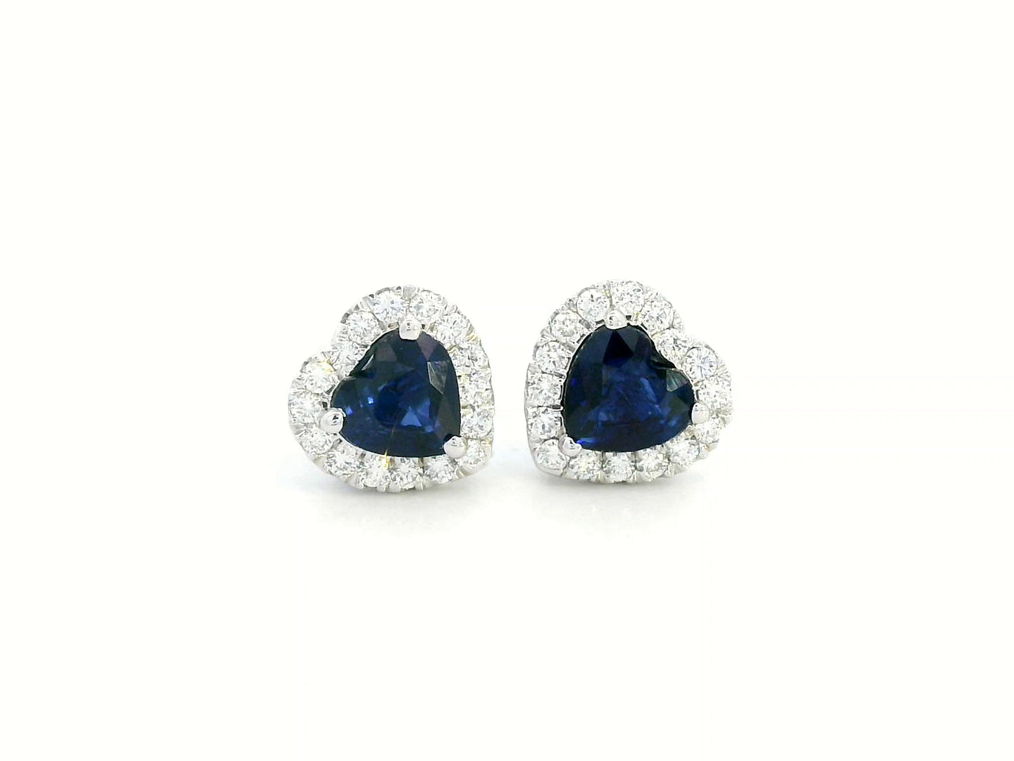 18K white gold heart-shaped sapphire and diamond halo stud earrings featuring a 1.40-carat deep blue sapphire and 0.33-carat round diamonds, perfect for fine jewelry lovers, birthdays, and September birthstone gifts.