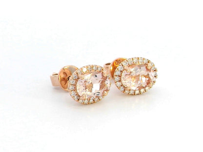 Elegant 18K gold stud earrings featuring 1.40 carats of oval-cut morganite gemstones, each encircled by a halo of 0.19 carats of round diamonds, secured with a push-back closure for timeless sophistication.







