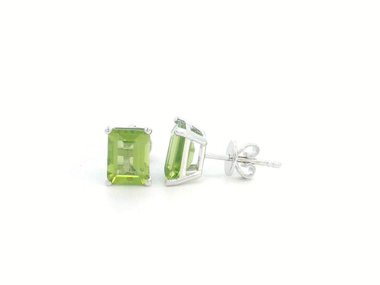 Emerald cut Peridot earrings in 18K white gold, featuring 3.30 carats of vibrant green gemstones in a four-prong setting, symbolizing strength and renewal for those born in August