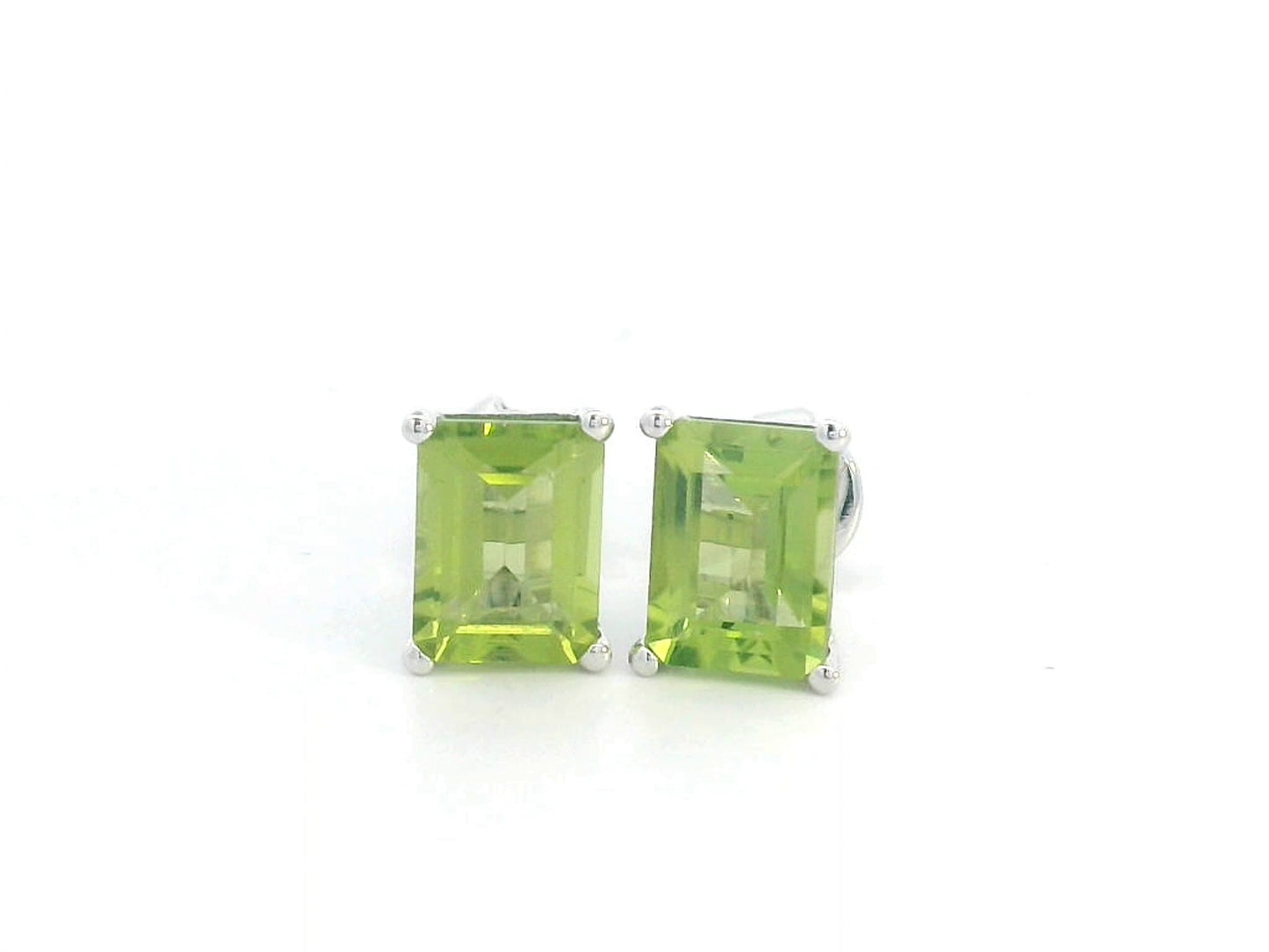 Emerald cut Peridot earrings in 18K white gold, featuring 3.30 carats of vibrant green gemstones in a four-prong setting, symbolizing strength and renewal for those born in August