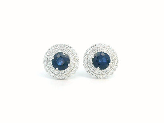 Round Sapphire and Diamond halo stud earrings in 18K white gold, featuring 2.27 carats of deep blue Sapphire and 0.81 carats of sparkling Diamonds.