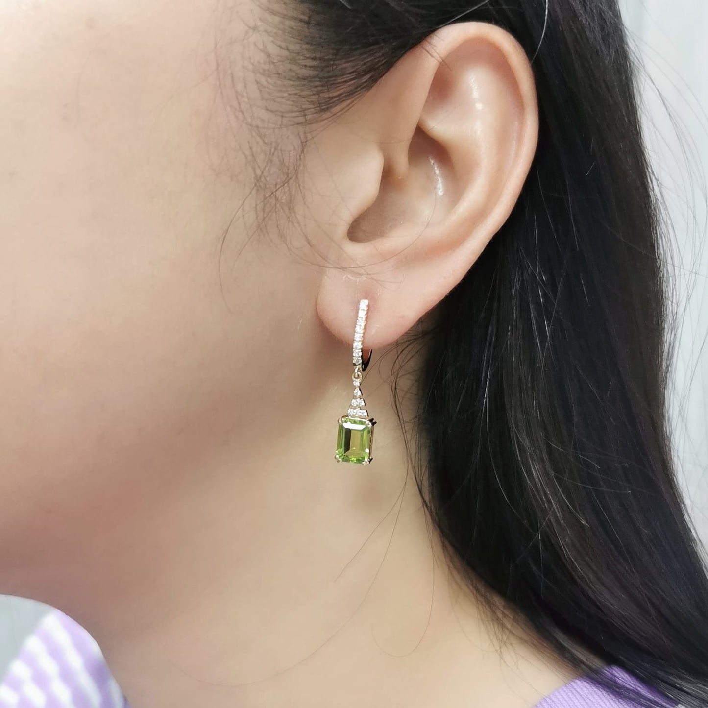 Emerald-cut Peridot and diamond drop earrings in 18K white gold, featuring vibrant green gemstones and brilliant diamond accents.