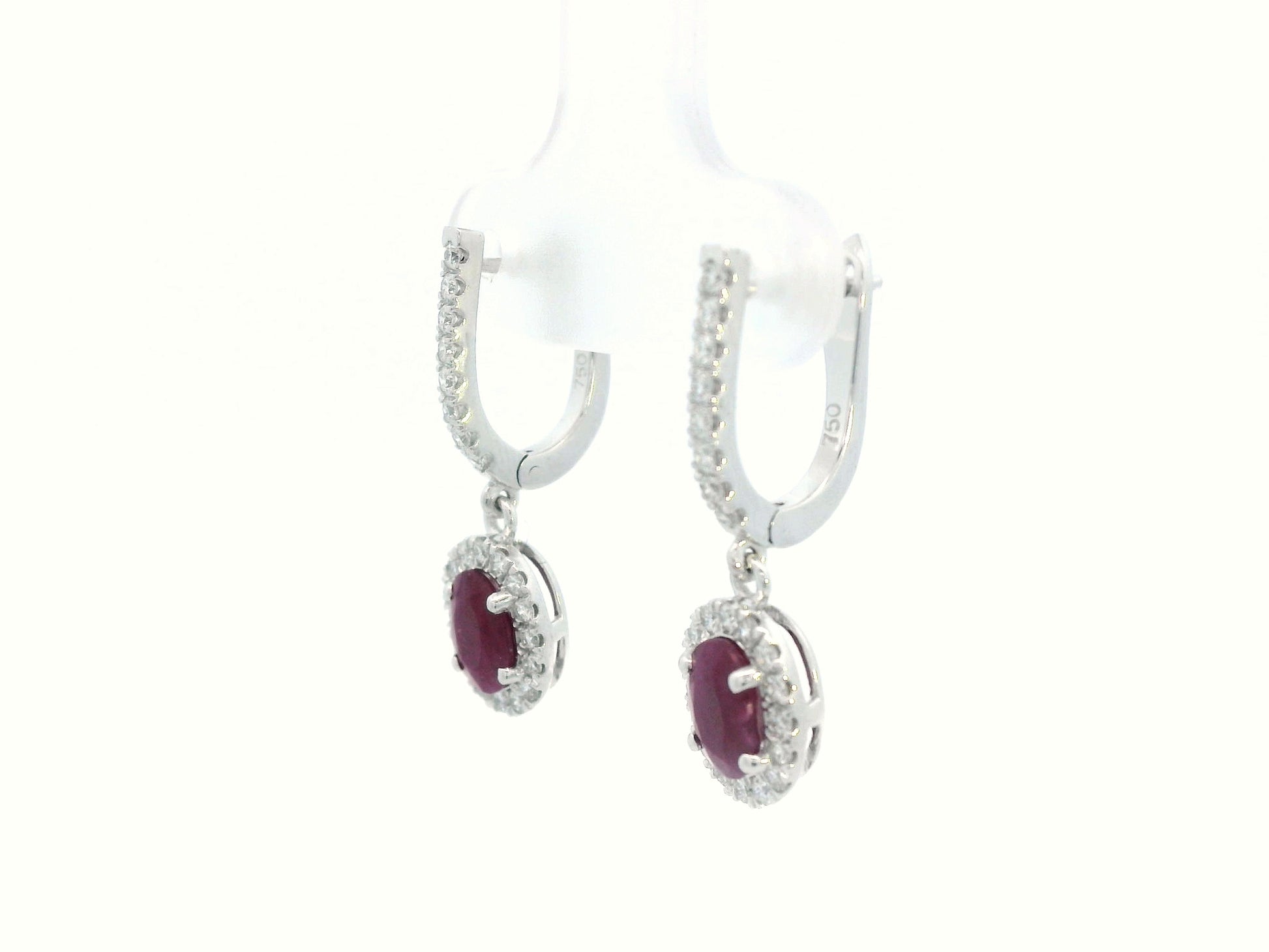 Elegant oval-cut Ruby and diamond halo drop earrings in 18K white gold, featuring 1.40 carats of deep red Rubies and 0.43 carats of sparkling diamonds.