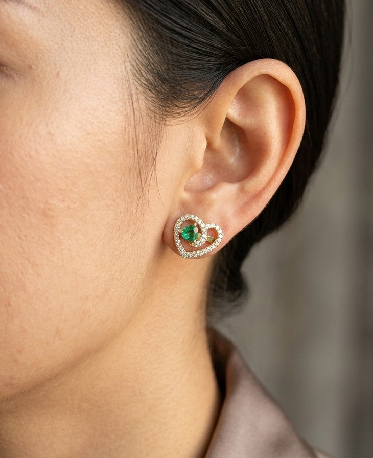 Heart shaped emerald and diamond earrings in 18K yellow gold with green emerald centres and intertwined diamond openwork design