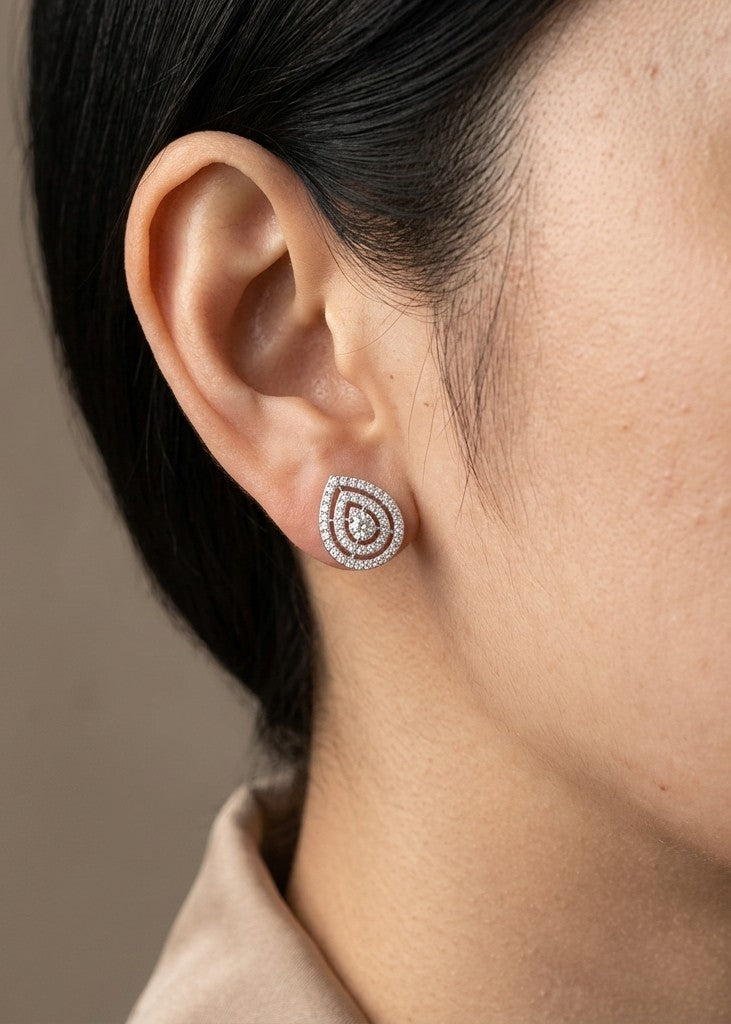 Diamond teardrop stud earrings in 18K white gold featuring concentric rows of round diamonds with elegant openwork detailing