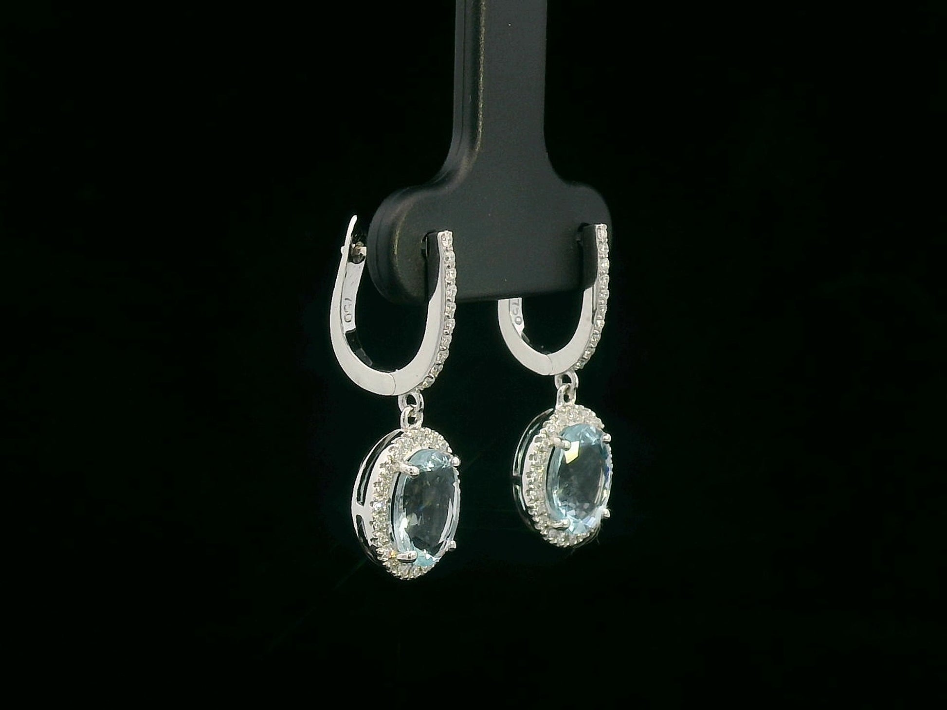 18K gold drop earrings with oval aquamarine center stones and diamond halo design

