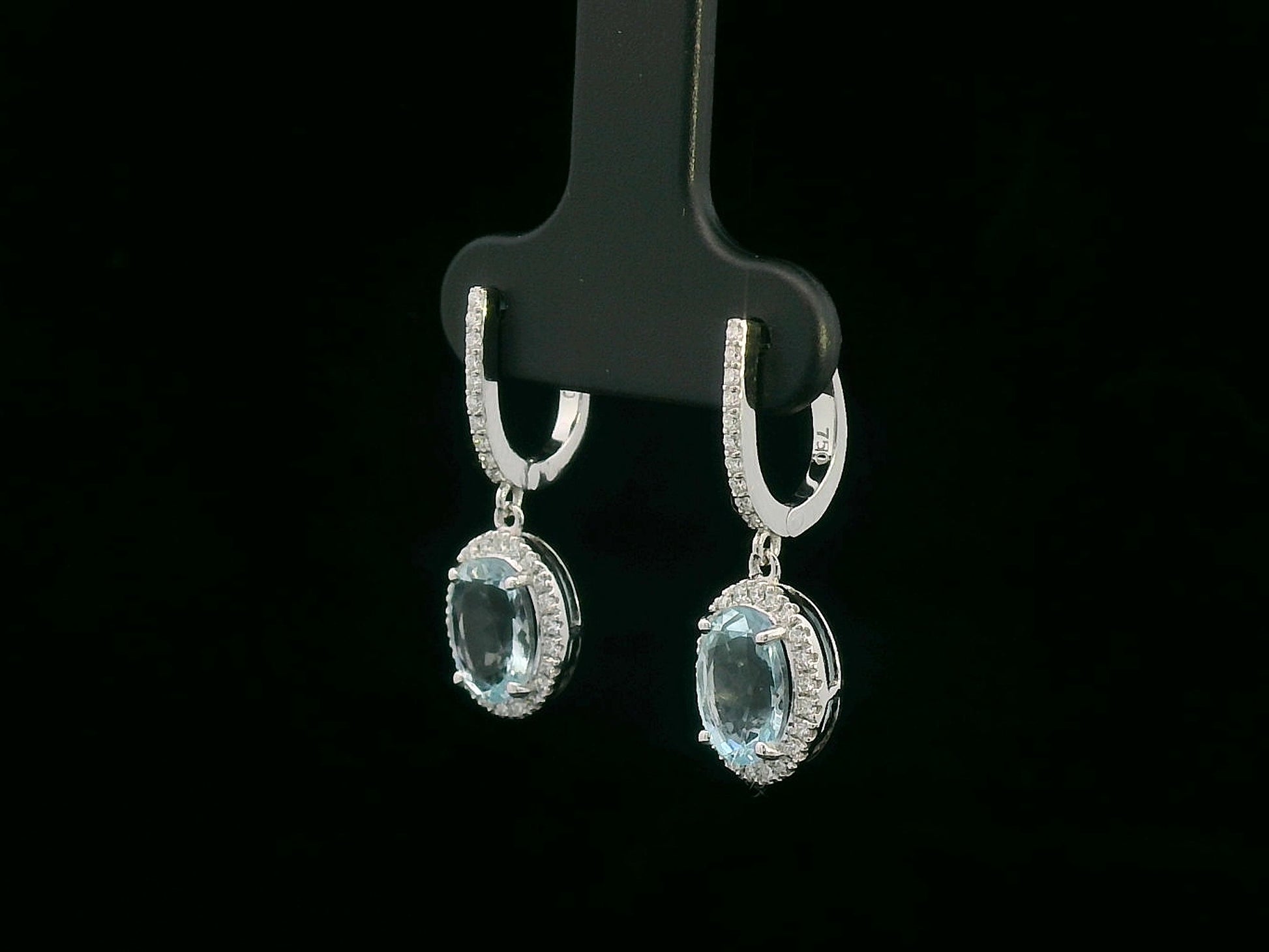 18K gold drop earrings with oval aquamarine center stones and diamond halo design

