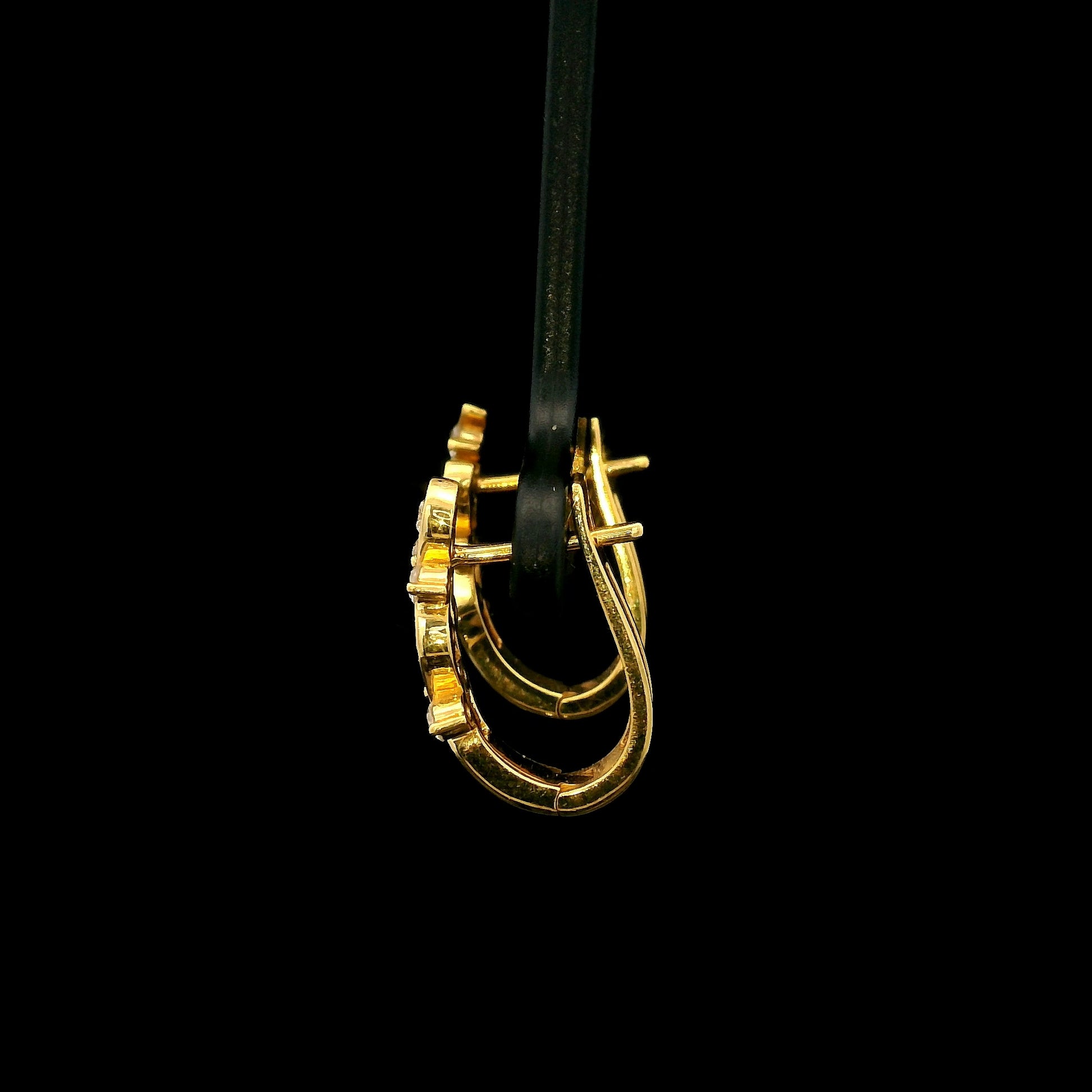 18K yellow gold diamond wave hoop earrings featuring flowing open gold curves with scattered round brilliant diamonds.