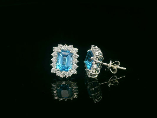 Emerald-cut blue topaz stud earrings framed by a scalloped diamond halo in 18K gold 
