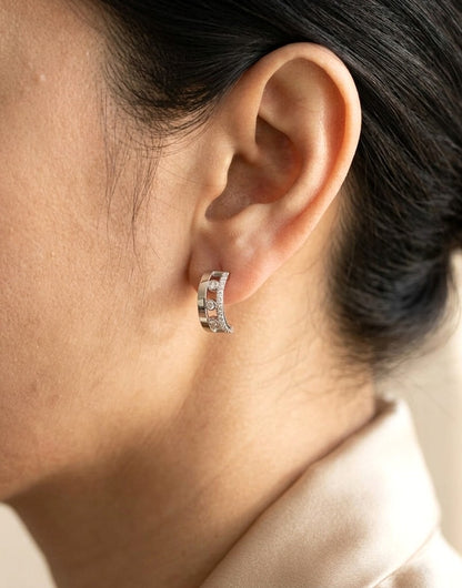 Diamond curved stud earrings in 18K white gold with three bezel-set round diamonds and pavé diamond detailing