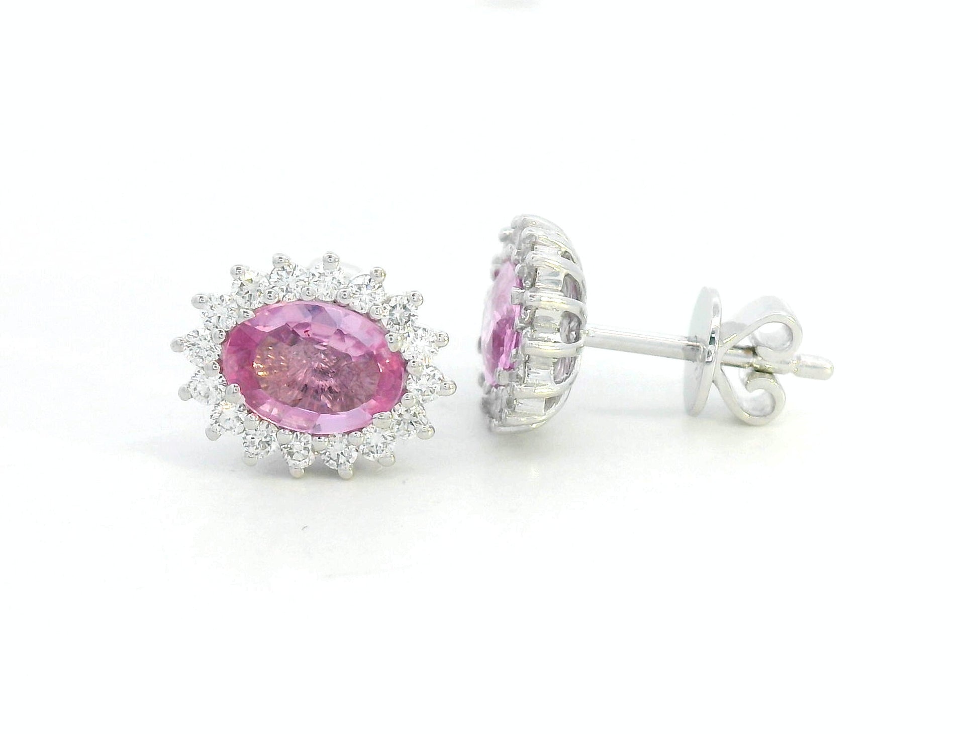 Oval pink sapphire stud earrings with diamond starburst halo in 18K gold