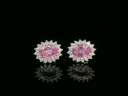 Oval pink sapphire stud earrings with diamond starburst halo in 18K gold
