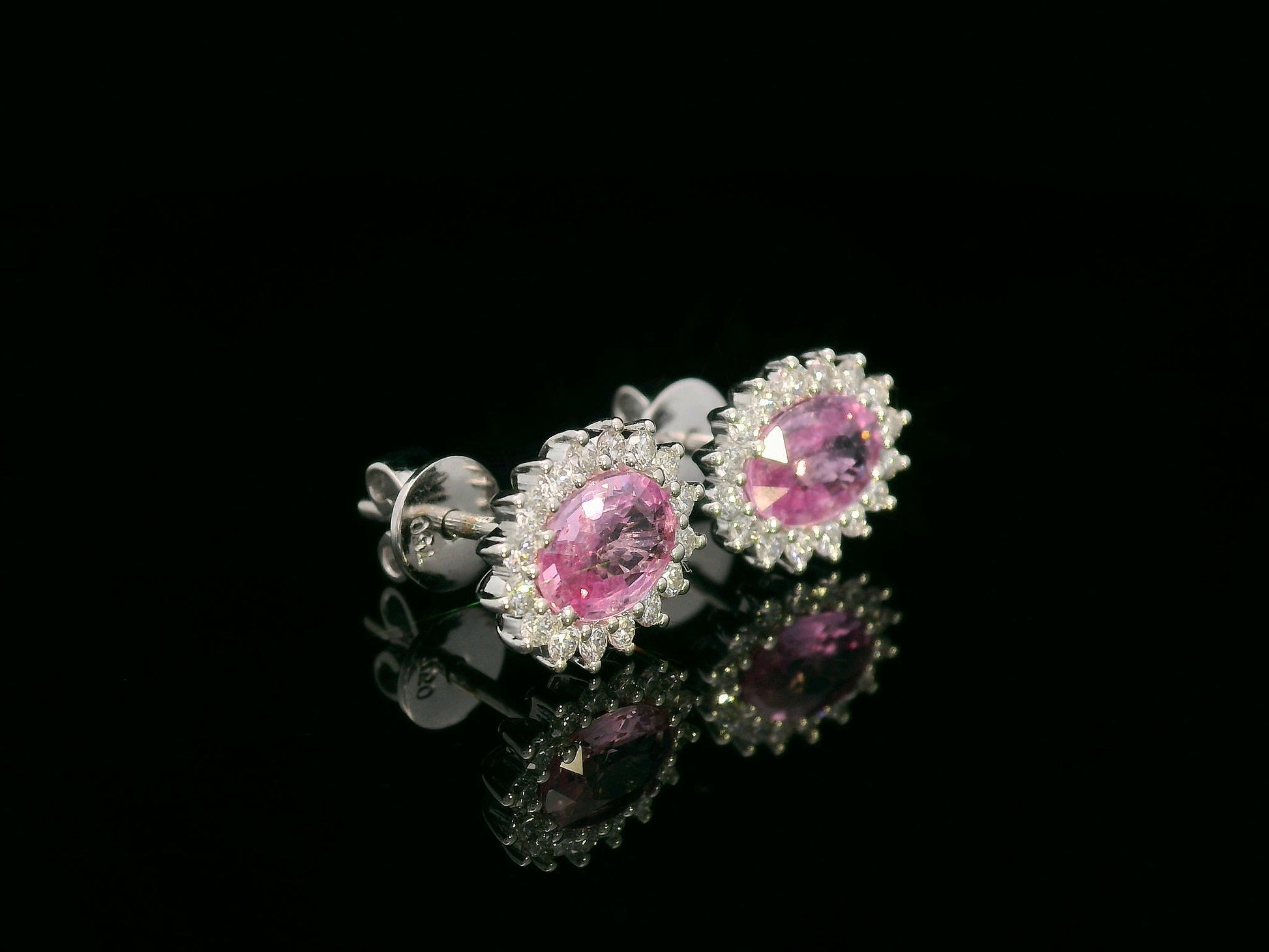 Oval pink sapphire stud earrings with diamond starburst halo in 18K gold
