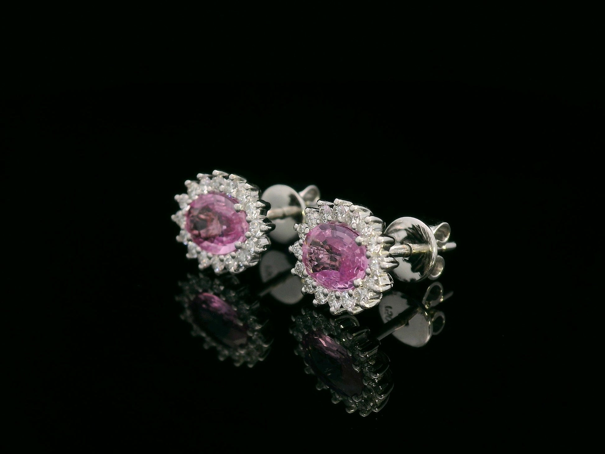 Oval pink sapphire stud earrings with diamond starburst halo in 18K gold