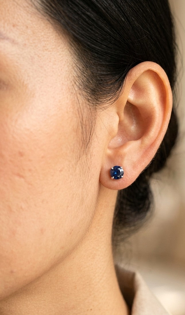 Round blue sapphire stud earrings in 18K yellow gold with four-prong settings