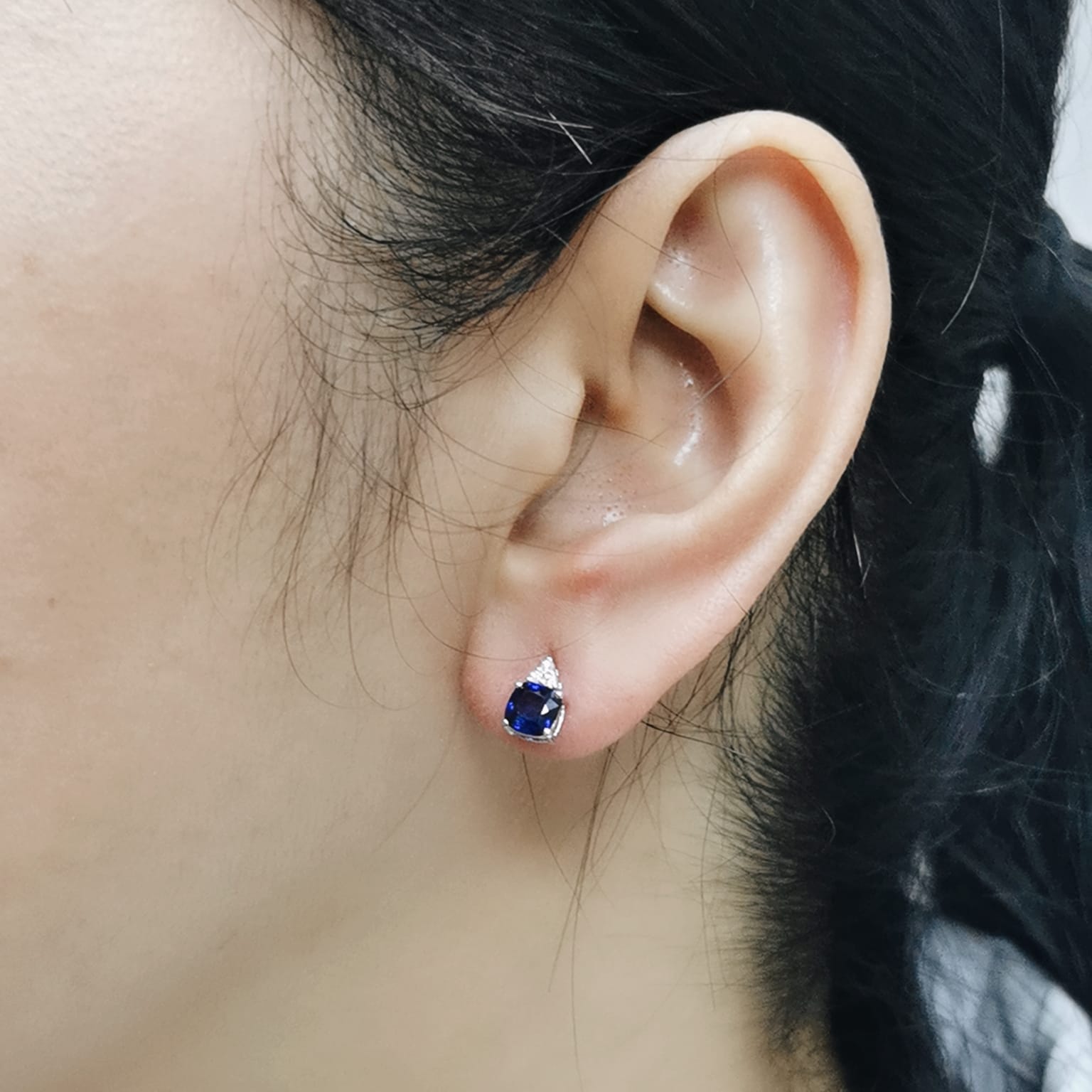 White gold stud earrings with cushion-cut sapphires and round diamonds