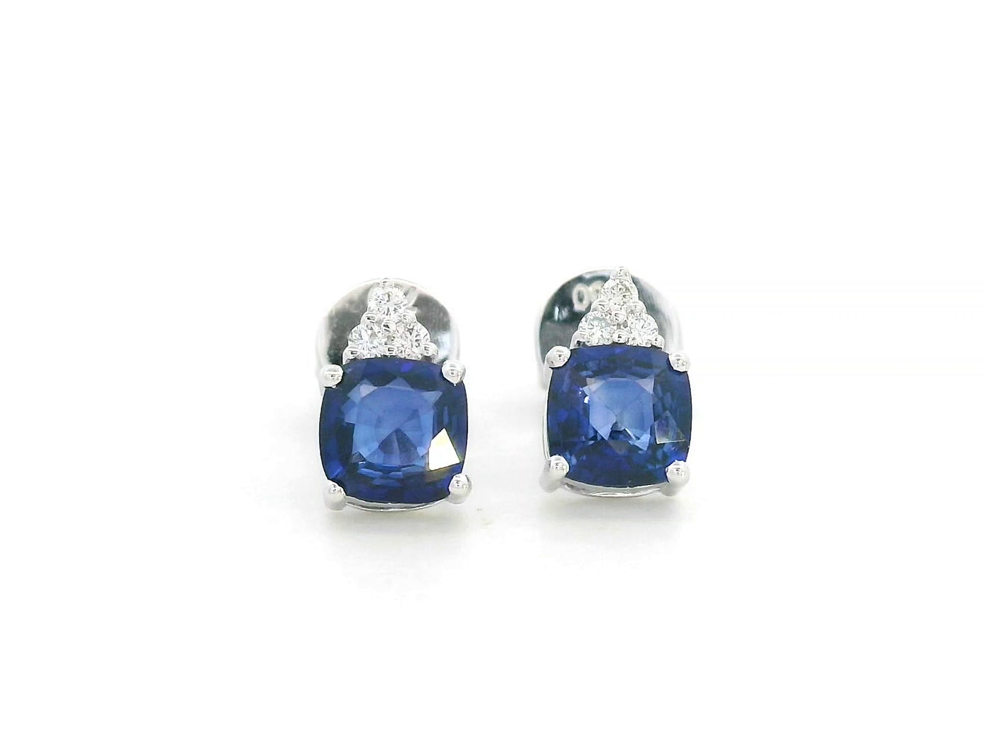 Cushion-cut blue sapphire earrings with three diamond accents